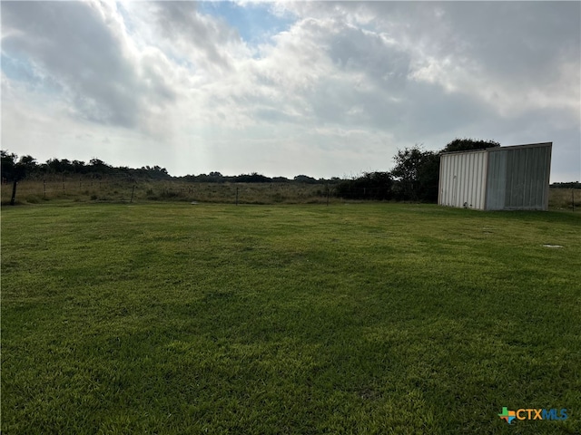 view of yard with a rural view and an outbuilding