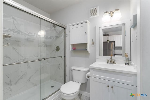 bathroom featuring vanity, toilet, and walk in shower