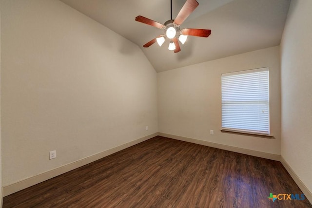 empty room with ceiling fan, vaulted ceiling, and dark hardwood / wood-style floors