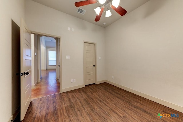 unfurnished bedroom with lofted ceiling, dark hardwood / wood-style flooring, and ceiling fan