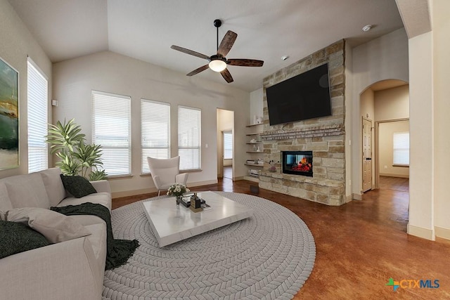 living room with vaulted ceiling, a fireplace, and ceiling fan