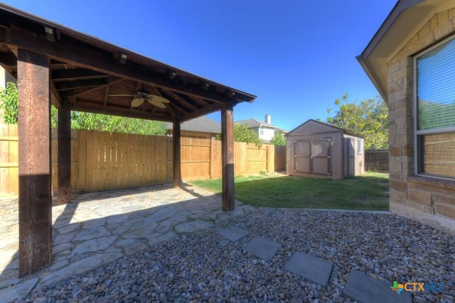 view of patio featuring a gazebo, ceiling fan, and a storage unit