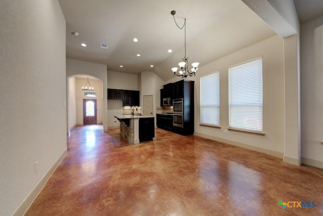 kitchen with hanging light fixtures, an island with sink, a breakfast bar, concrete flooring, and sink