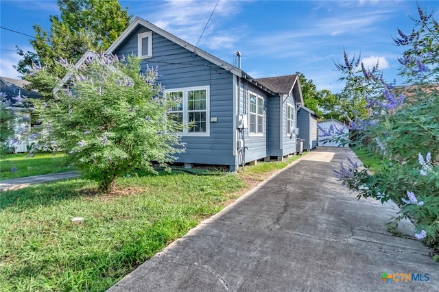 view of side of home with a yard