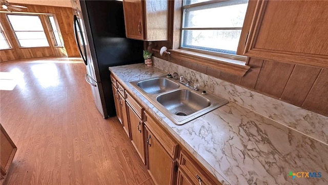902 Holly St, Copperas Cove, TX 76522 - kitchen featuring healthy amount of natural light, brown cabinetry, light wood-style floors, and freestanding refrigerator