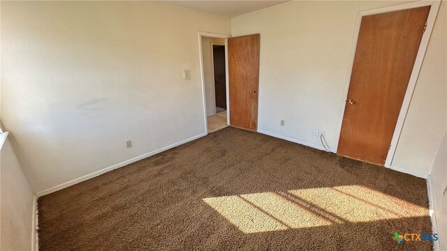 unfurnished bedroom featuring dark colored carpet