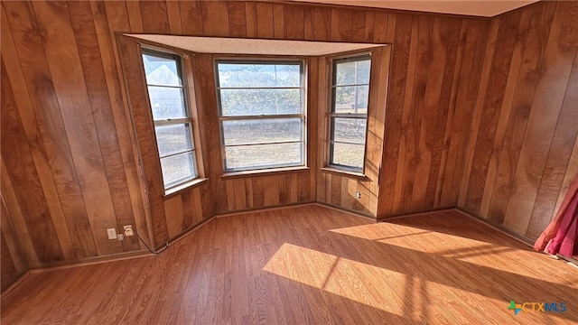 spare room with wooden walls and hardwood / wood-style floors