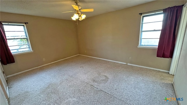 carpeted empty room featuring a textured ceiling and ceiling fan