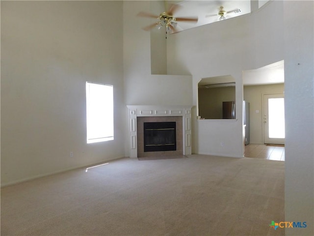 2302 Napier Dr, Killeen, TX 76542 - unfurnished living room with a high ceiling, carpet flooring, a tiled fireplace, and a ceiling fan