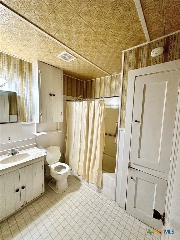 full bathroom featuring shower / tub combo with curtain, vanity, and toilet