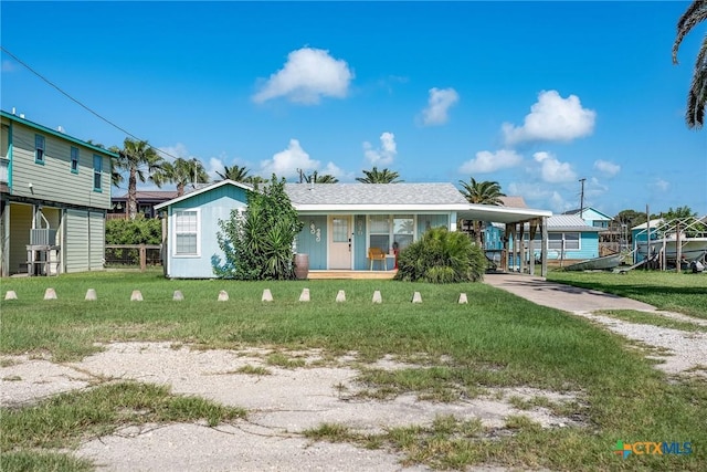 819 S Magnolia St, Rockport, TX 78382 - view of front of property featuring covered porch, driveway, a front yard, and an attached carport