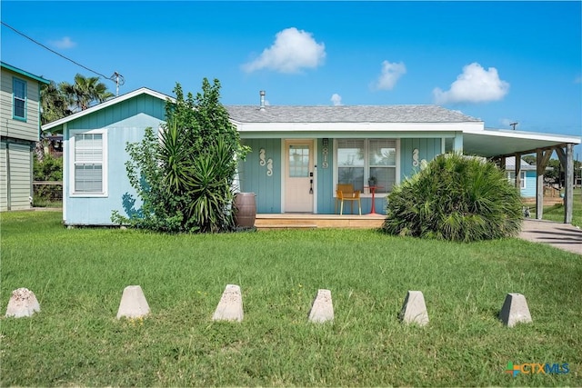 819 S Magnolia St, Rockport, TX 78382 - view of front of house with a carport, a porch, a front yard, and driveway