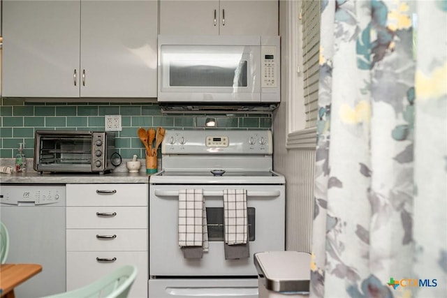 819 S Magnolia St, Rockport, TX 78382 - kitchen featuring white appliances, decorative backsplash, and light countertops