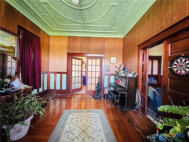 entrance foyer with an ornate ceiling, wooden walls, and wood finished floors