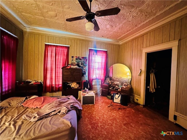 bedroom with an ornate ceiling, crown molding, wood walls, and ceiling fan