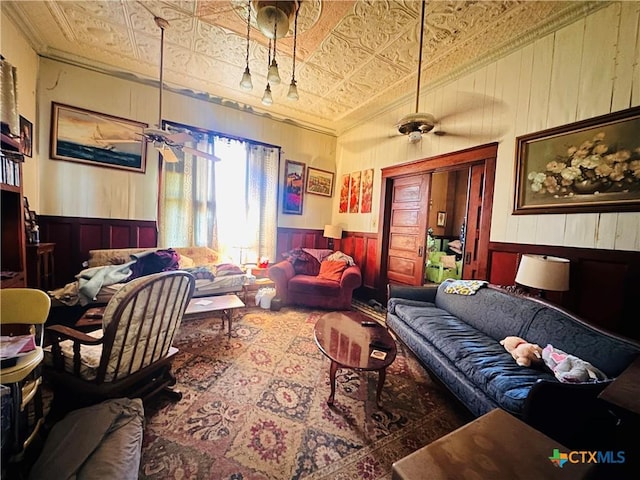 living area with a wainscoted wall, an ornate ceiling, and crown molding