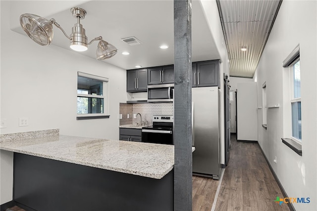 kitchen featuring visible vents, plenty of natural light, a peninsula, and appliances with stainless steel finishes