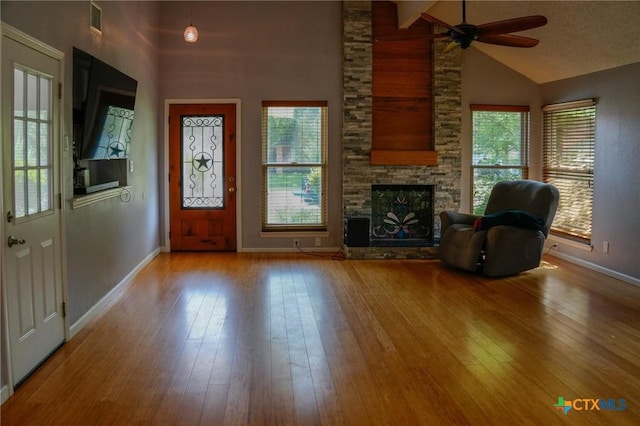 22631 John Rolfe Ln, Katy, TX 77449 - foyer entrance with ceiling fan, high vaulted ceiling, a fireplace, and hardwood / wood-style flooring