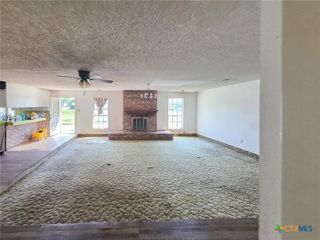 403 Schell Rd, Victoria, TX 77904 - unfurnished living room featuring carpet, a brick fireplace, plenty of natural light, a ceiling fan, and a textured ceiling