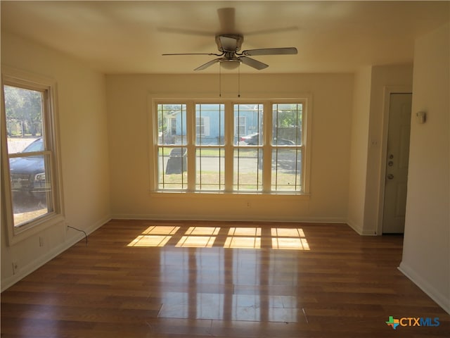 spare room with plenty of natural light, dark hardwood / wood-style floors, and ceiling fan