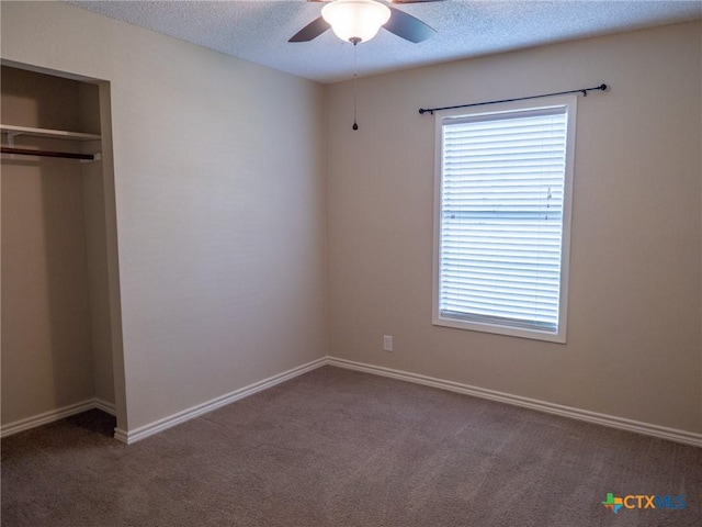 unfurnished bedroom with a textured ceiling, multiple windows, and carpet