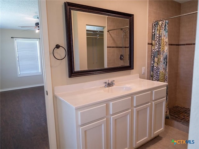 full bathroom with a tile shower, vanity, a textured ceiling, and ceiling fan