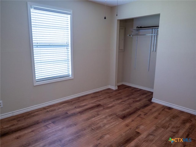 unfurnished bedroom featuring baseboards, a closet, and wood finished floors