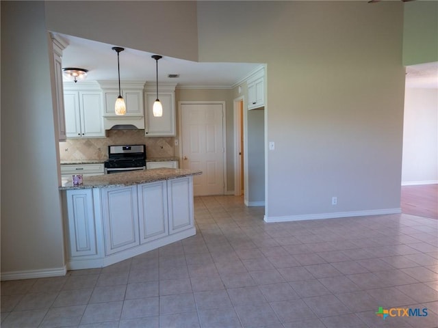 kitchen featuring light stone counters, baseboards, tasteful backsplash, gas range, and custom range hood