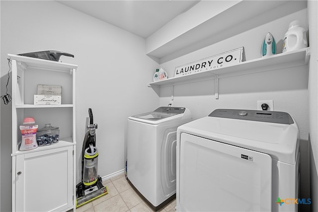 clothes washing area featuring washing machine and dryer and light tile patterned floors