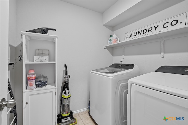 laundry area featuring washer and dryer and light tile patterned floors