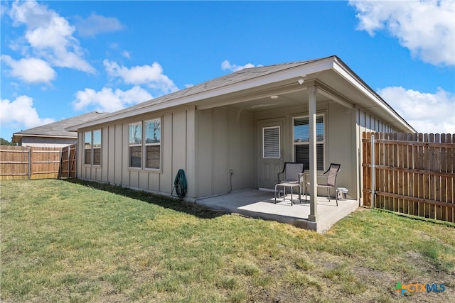 back of property with a yard and a patio area