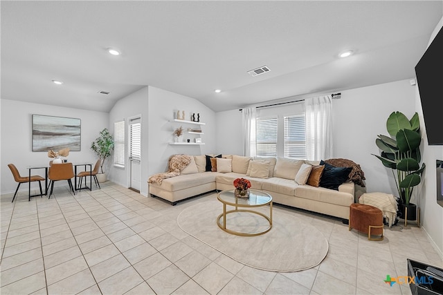 living room with light tile patterned flooring, plenty of natural light, and vaulted ceiling