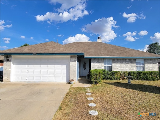 single story home featuring a garage and a front yard