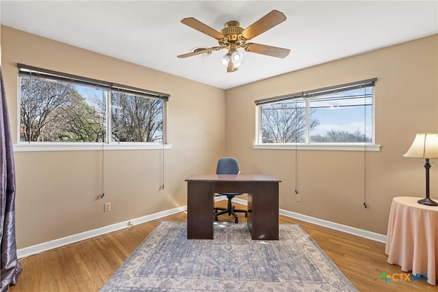 office area featuring wood finished floors, a ceiling fan, and baseboards