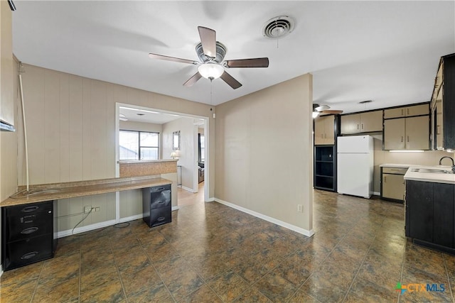 interior space with visible vents, a sink, baseboards, and ceiling fan