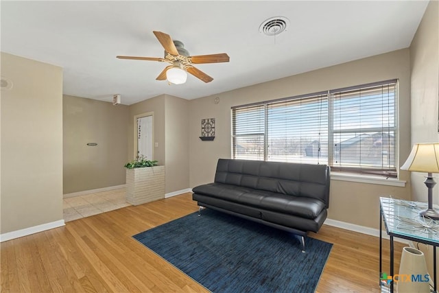 living room with a ceiling fan, baseboards, visible vents, and wood finished floors