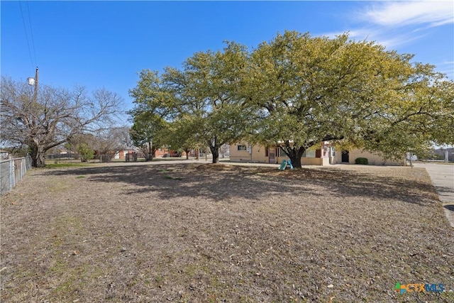 view of property hidden behind natural elements with fence