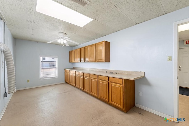 kitchen with a drop ceiling, visible vents, and baseboards