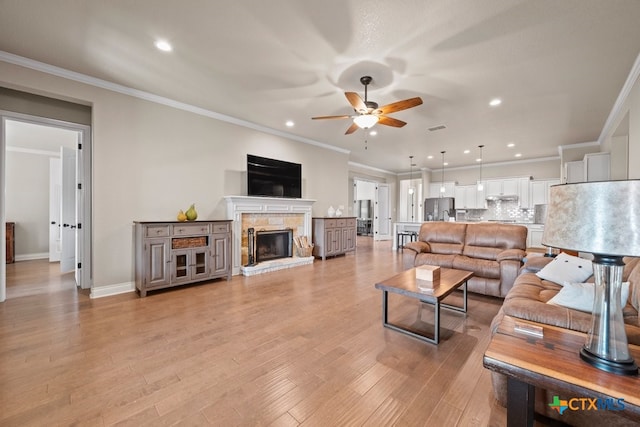 1169 Creek Cyn, New Braunfels, TX 78132 - living area with a ceiling fan, a fireplace, recessed lighting, ornamental molding, and light wood finished floors