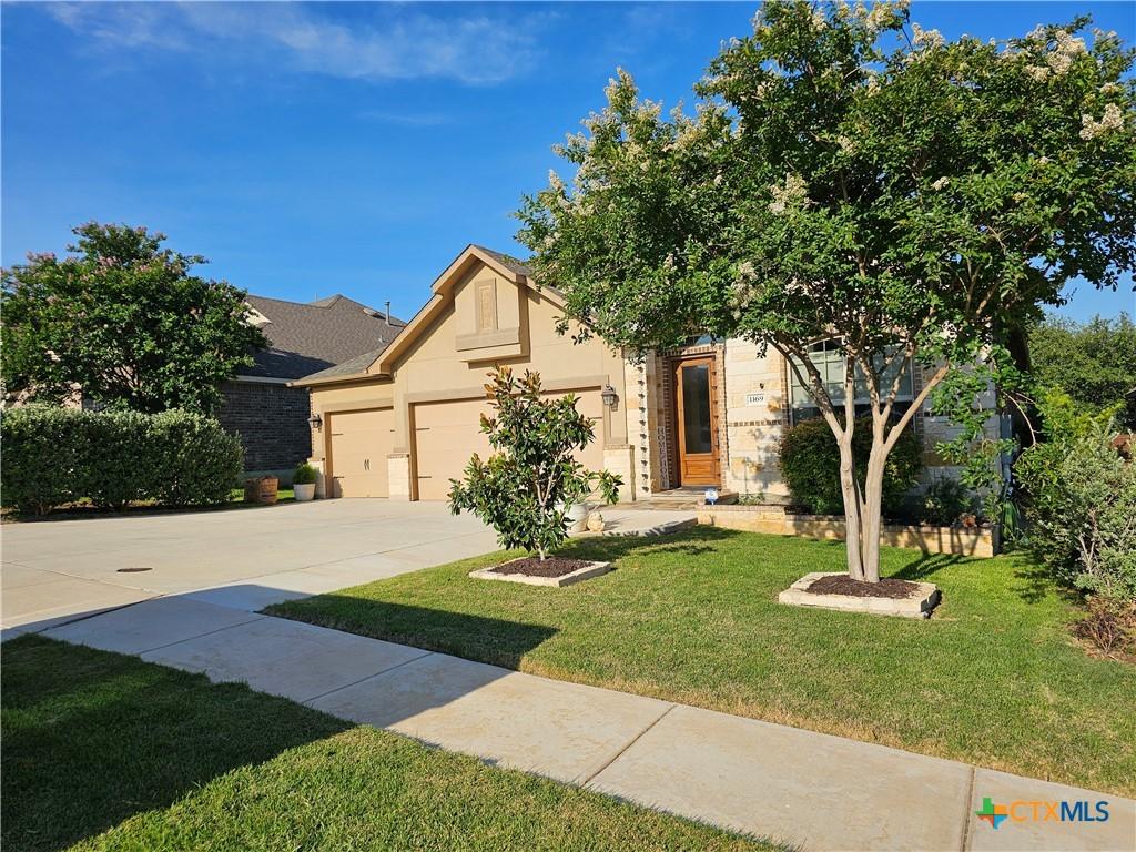 1169 Creek Cyn, New Braunfels, TX 78132 - view of front of home featuring a front lawn, an attached garage, driveway, and stucco siding