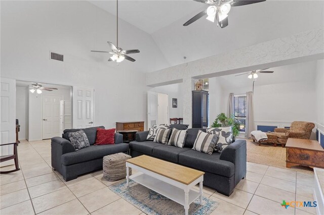 living area featuring light tile patterned floors, a ceiling fan, and high vaulted ceiling