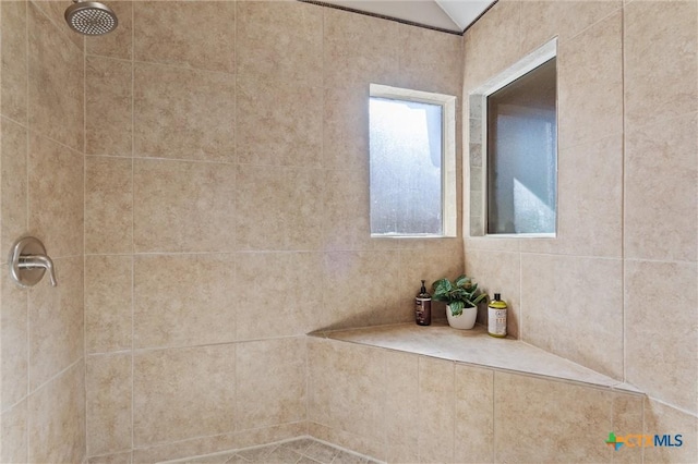 bathroom featuring tiled shower and vaulted ceiling