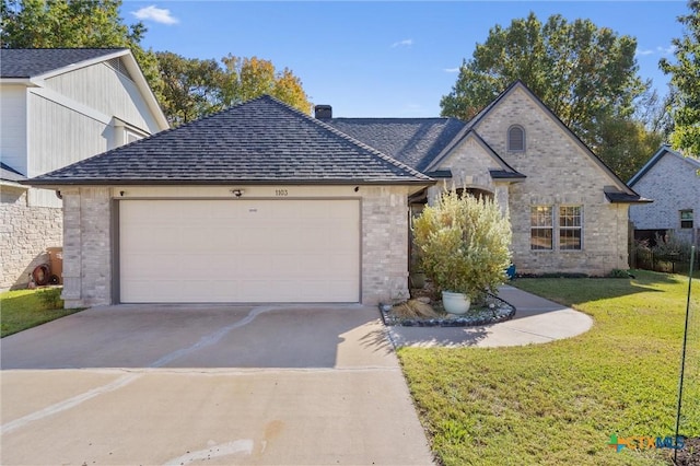 view of front of house featuring driveway, a garage, a front lawn, brick siding, and a shingled roof