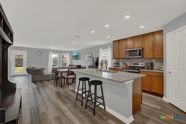 kitchen featuring a wealth of natural light, open floor plan, stainless steel appliances, and a sink