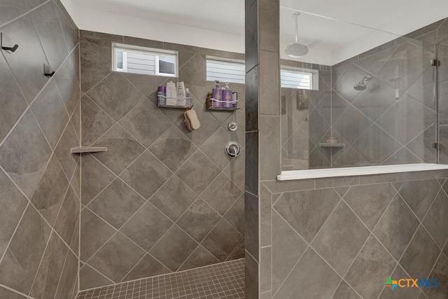 bathroom with a wealth of natural light and tiled shower