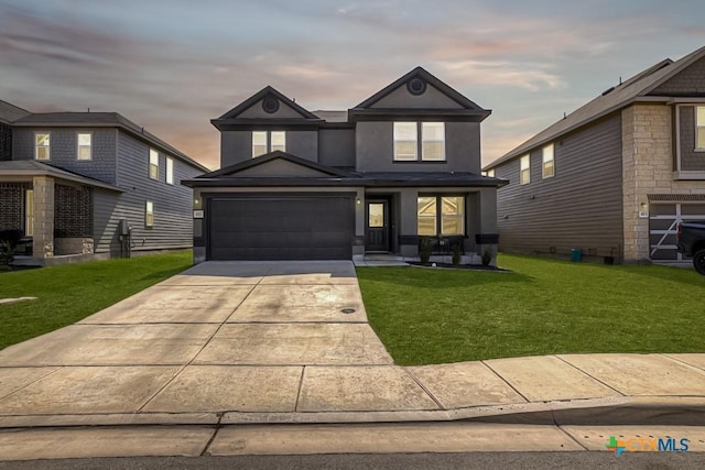 view of front of property featuring a yard, a garage, driveway, and stucco siding