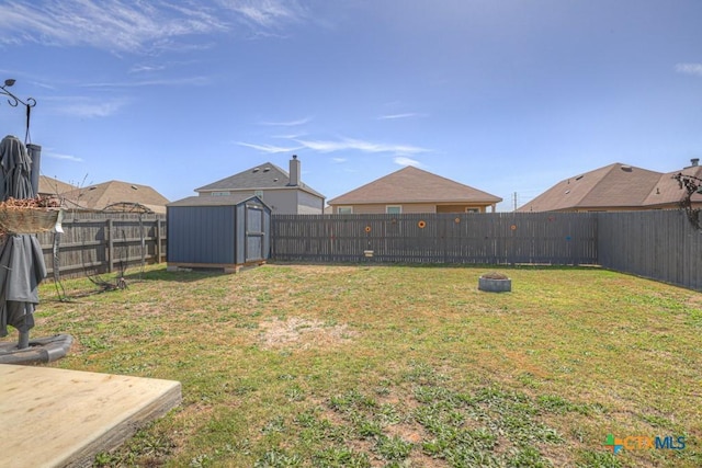 view of yard with a fenced backyard, a storage unit, and an outdoor structure