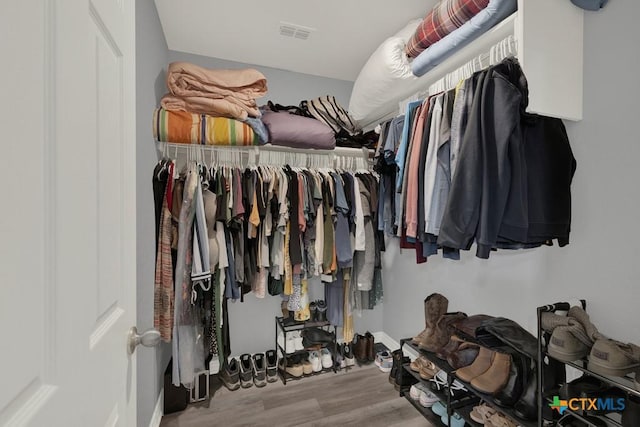 walk in closet with wood finished floors and visible vents