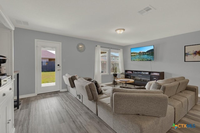 living area featuring visible vents, baseboards, and light wood-style flooring