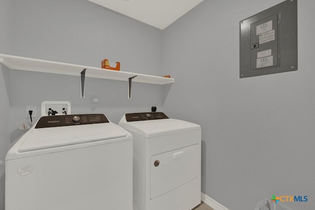 laundry room with electric panel, laundry area, washer and clothes dryer, and baseboards